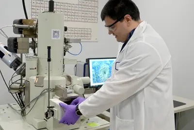 Mert Gezek loads a specimen into a scanning electron microscope.